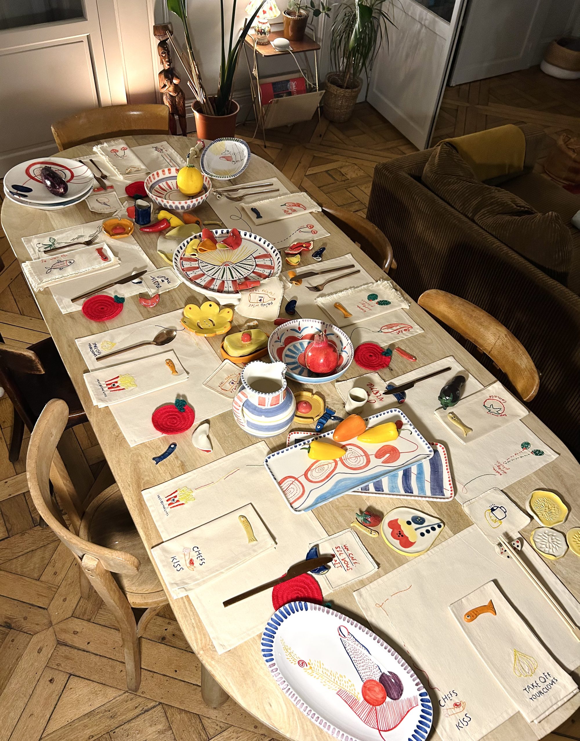 A table set with Sofr'art's embroidered napkins, hand-painted ceramics and crochet coasters